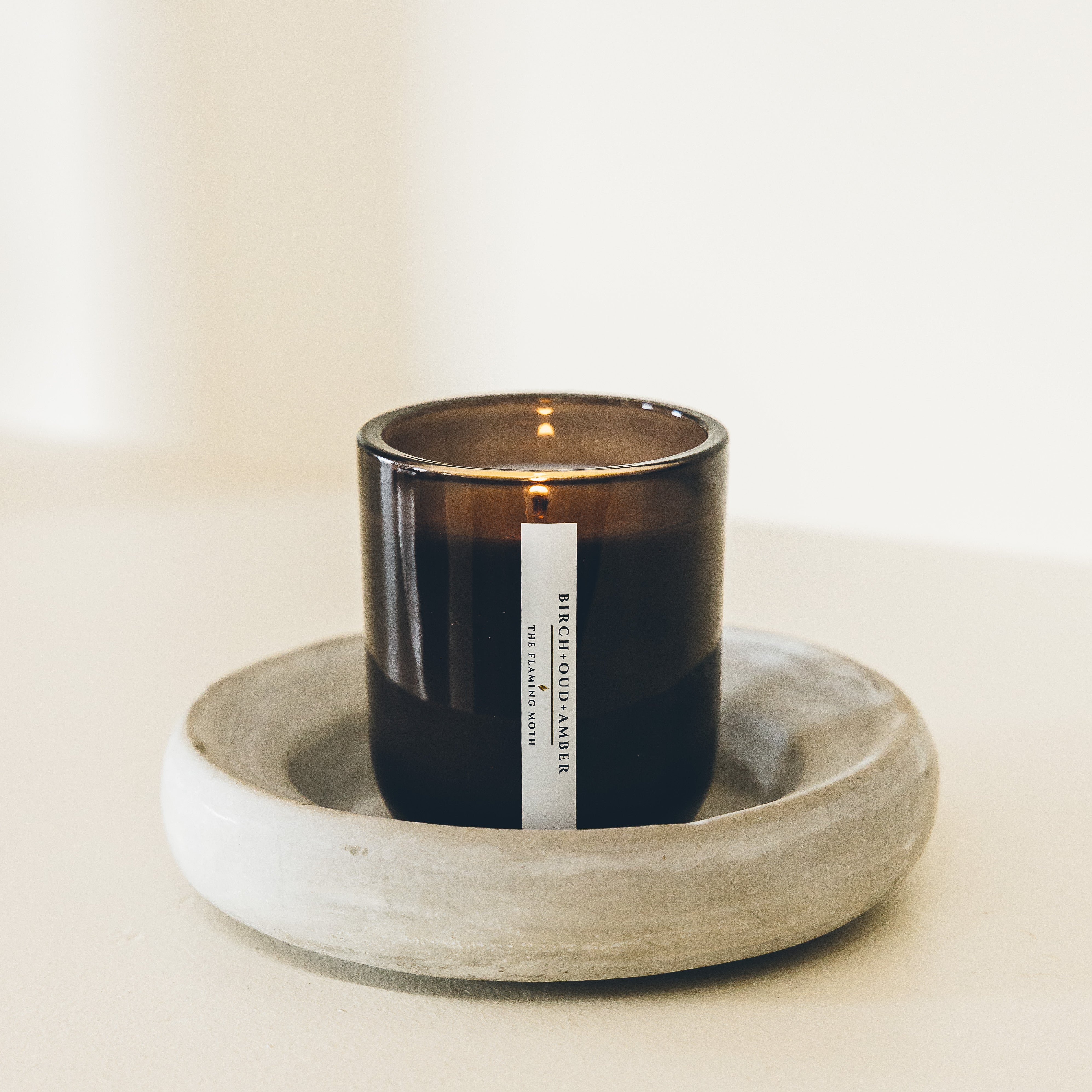 birch oud amber candle in a handmade ceramic dish