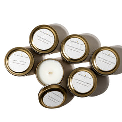 Set of candles in gold tins on a white background