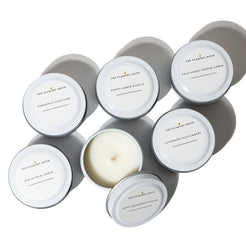 Set of candles in gray tins with white lids on a white background