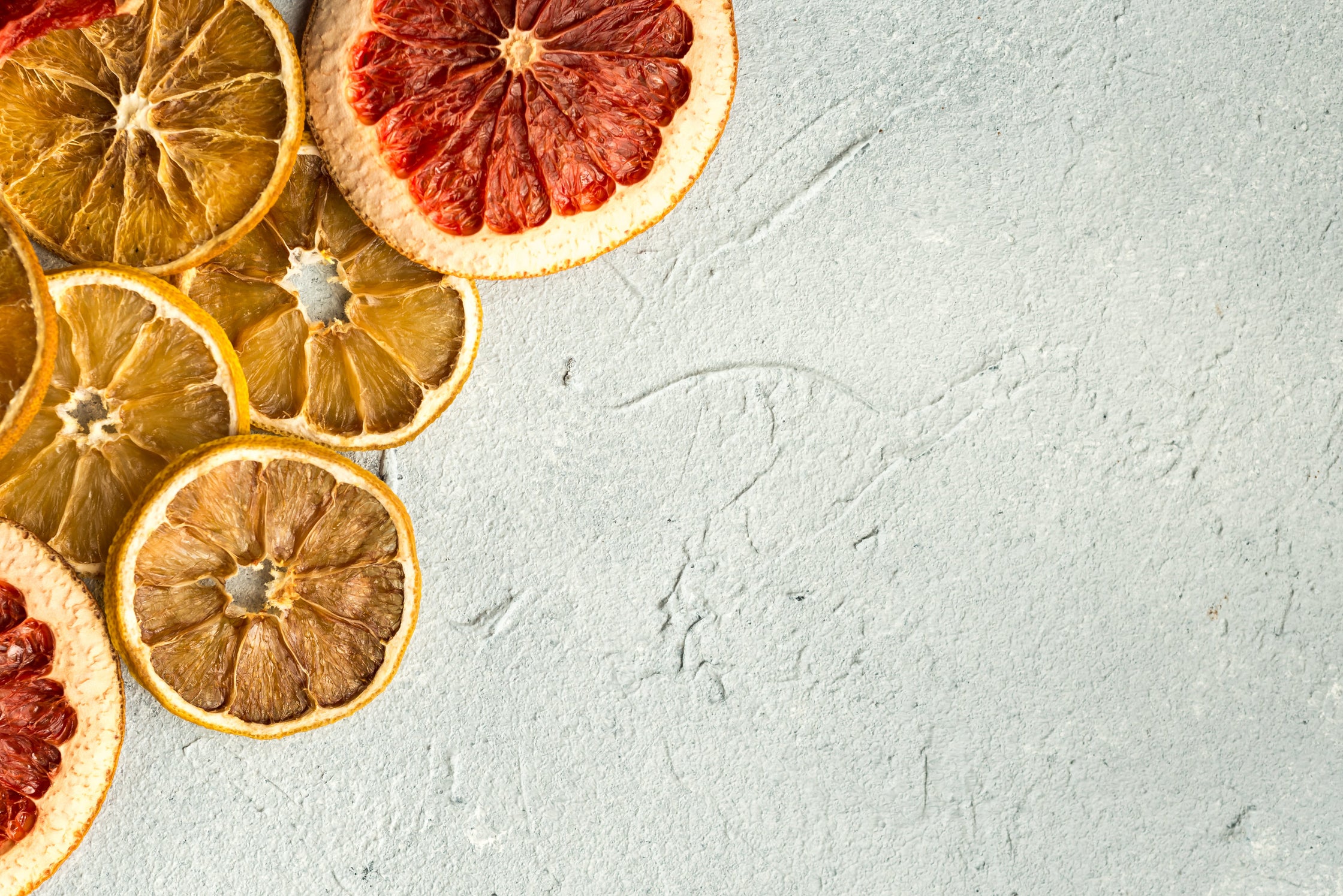 Dried citrus slices on a light gray textured surface