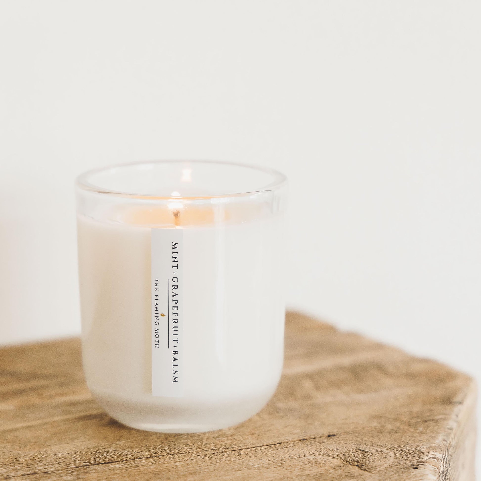 mint grapefruit balsam candle on wood table